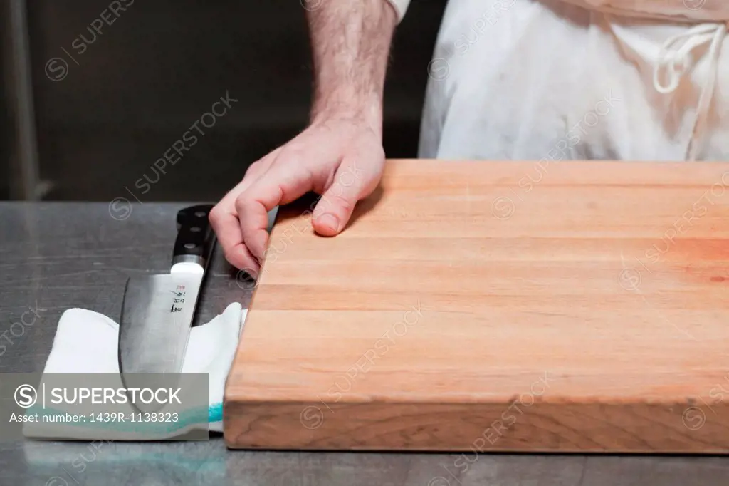 Close up of butcher with chopping board and knife