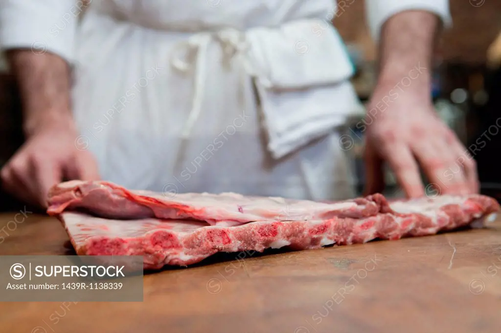 Butcher with pork ribs