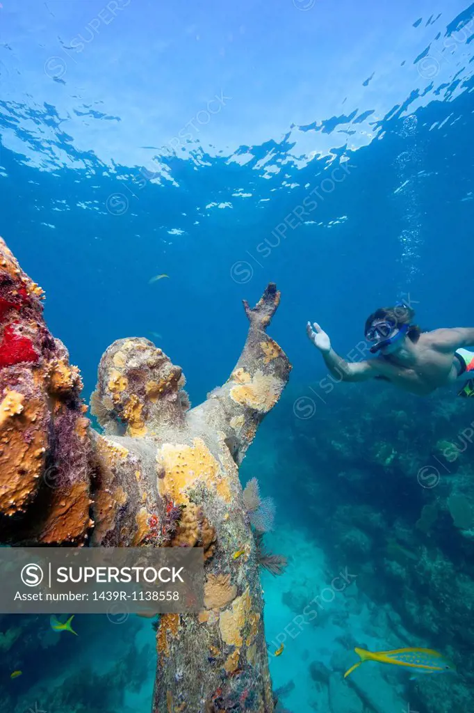 Snorkeler and underwater statue