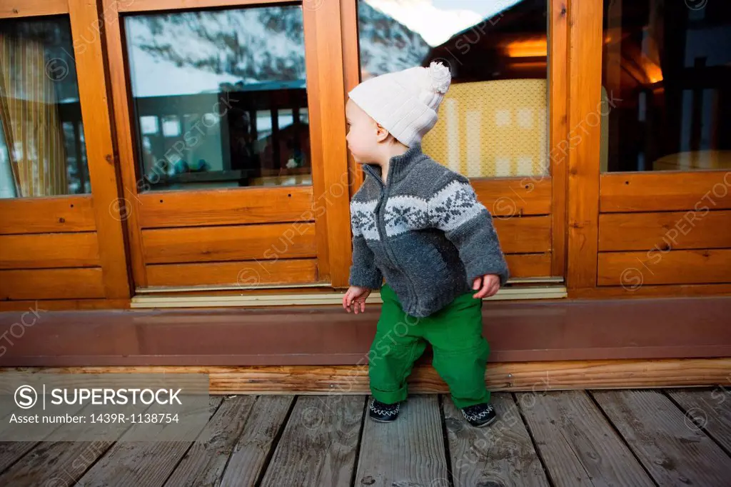 Boy outside wooden chalet