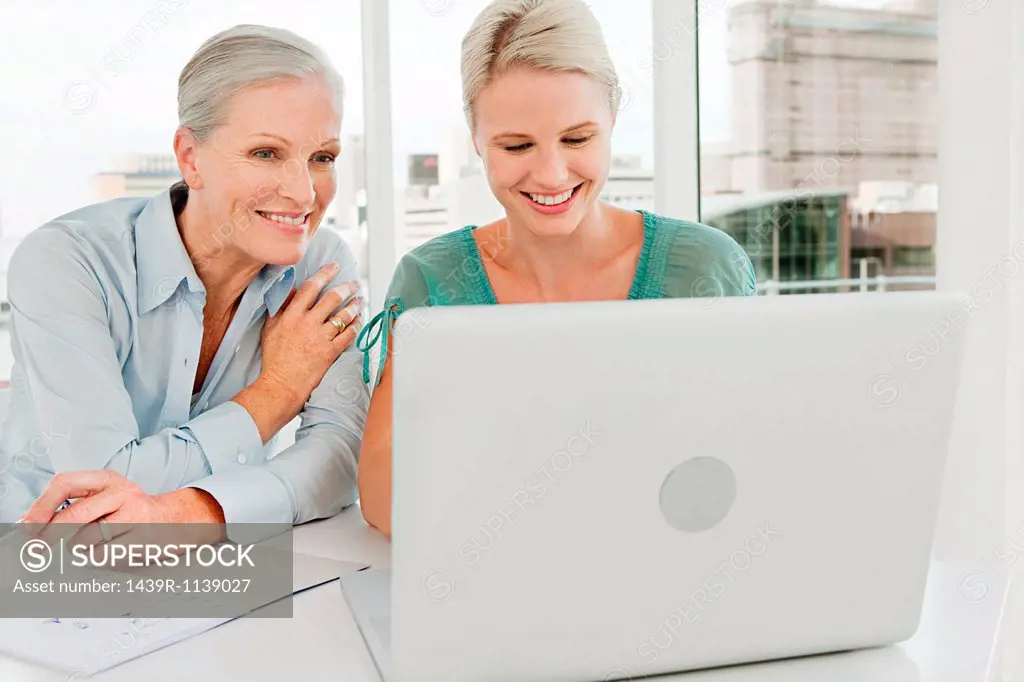 Two businesswomen using laptop in office