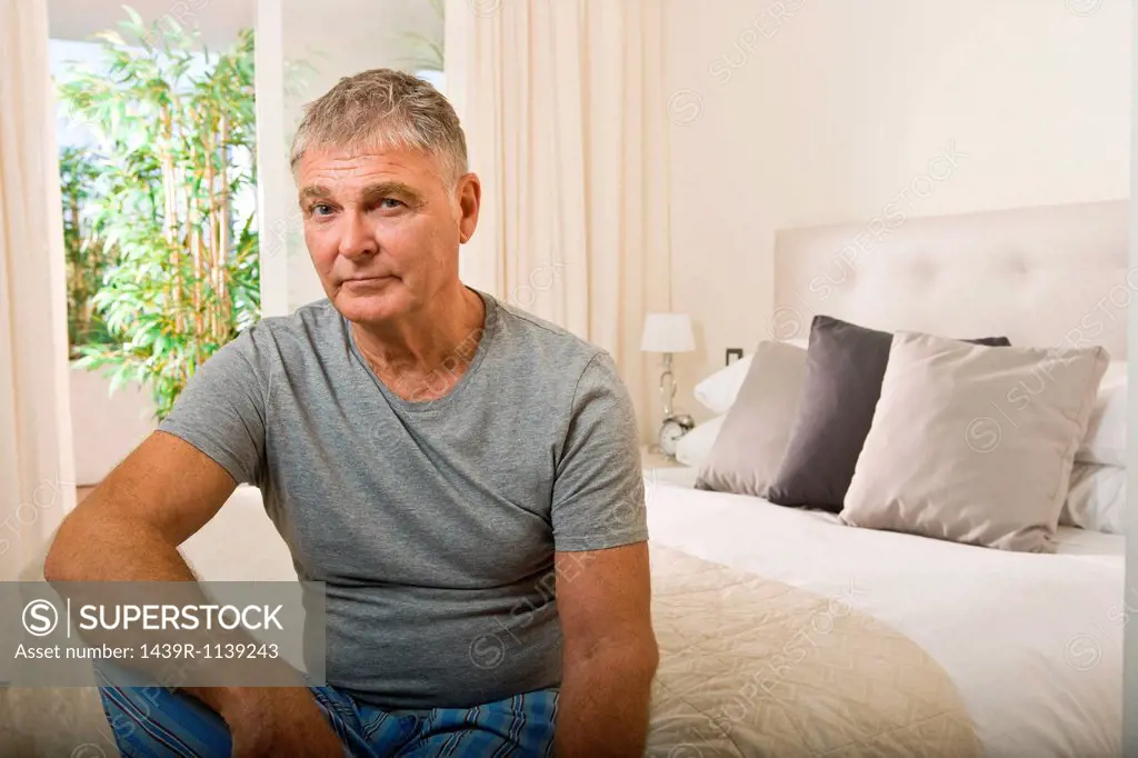Senior man sitting on bed