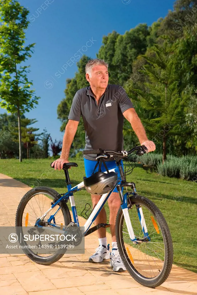 Senior male cyclist with bicycle
