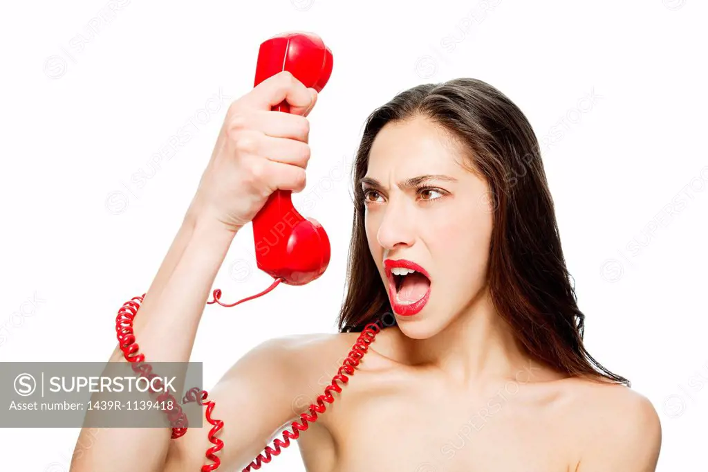 Angry woman shouting into red telephone