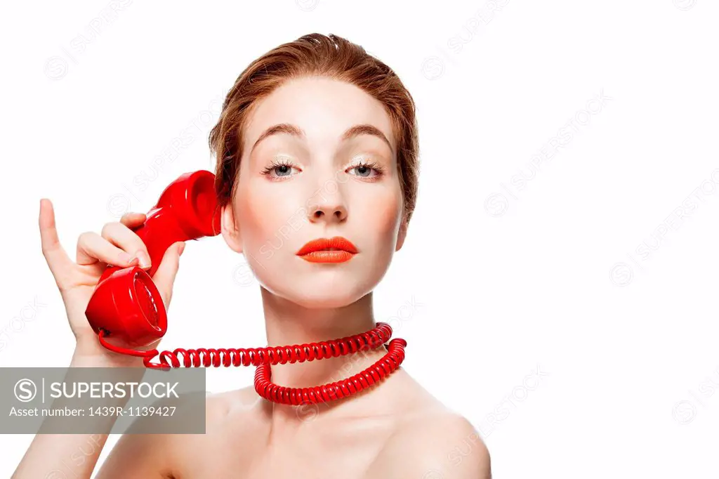 Woman with red telephone cord wrapped around neck