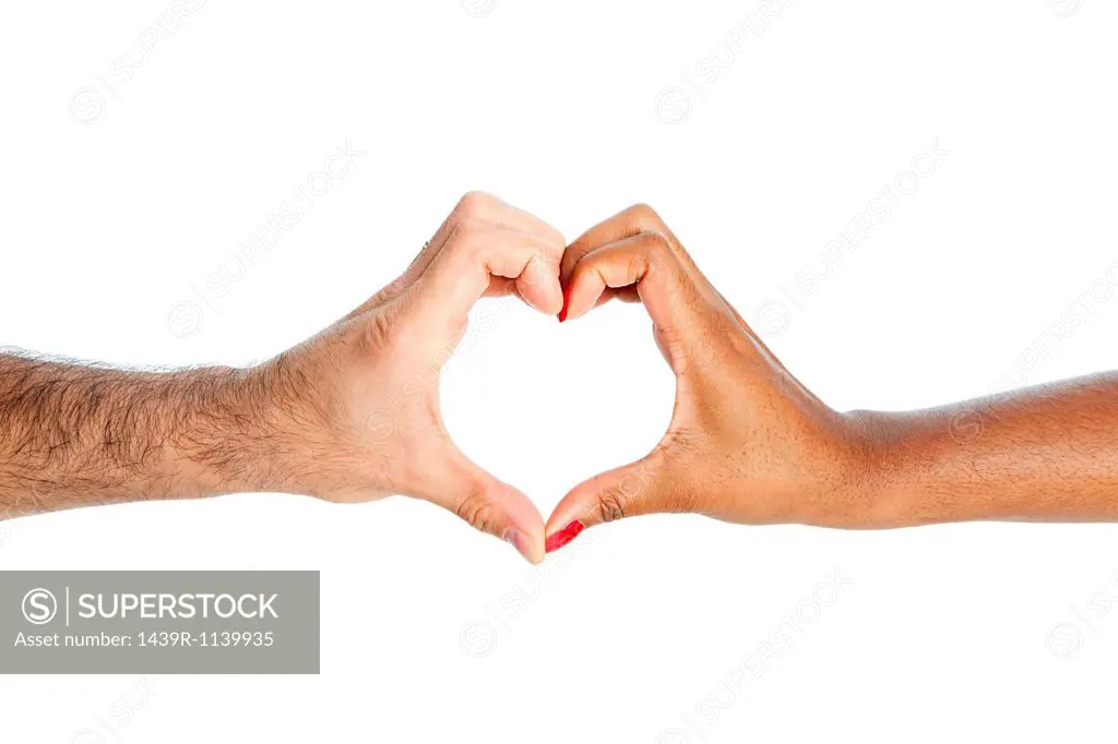 Mixed race couple making heart shape with hands