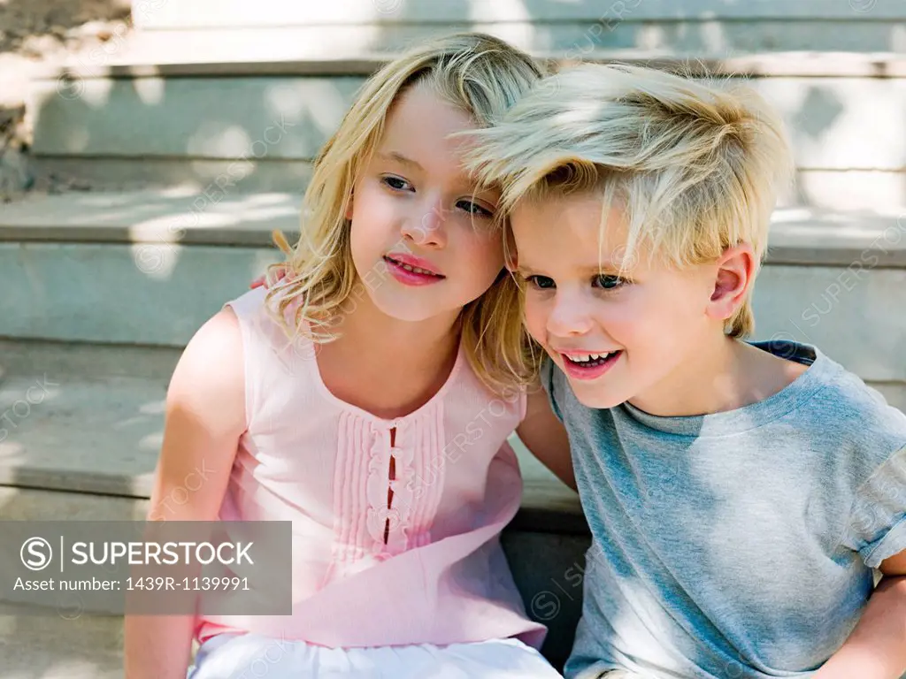 Brother and sister sitting on wooden steps