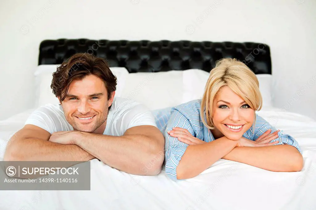 Couple lying on bed, portrait