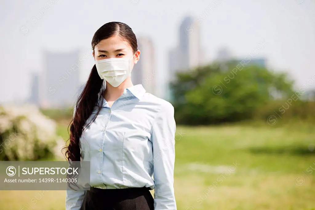 Young businesswoman wearing pollution mask