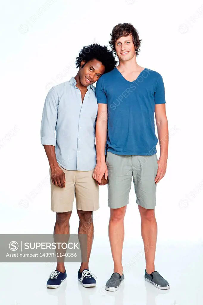 Gay couple standing against white background