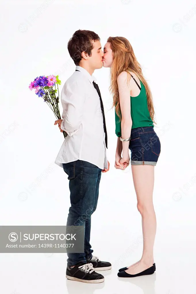 Young couple kissing against white background
