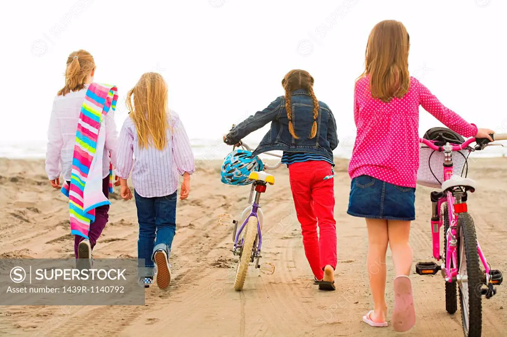 Girls walking over sand at beach