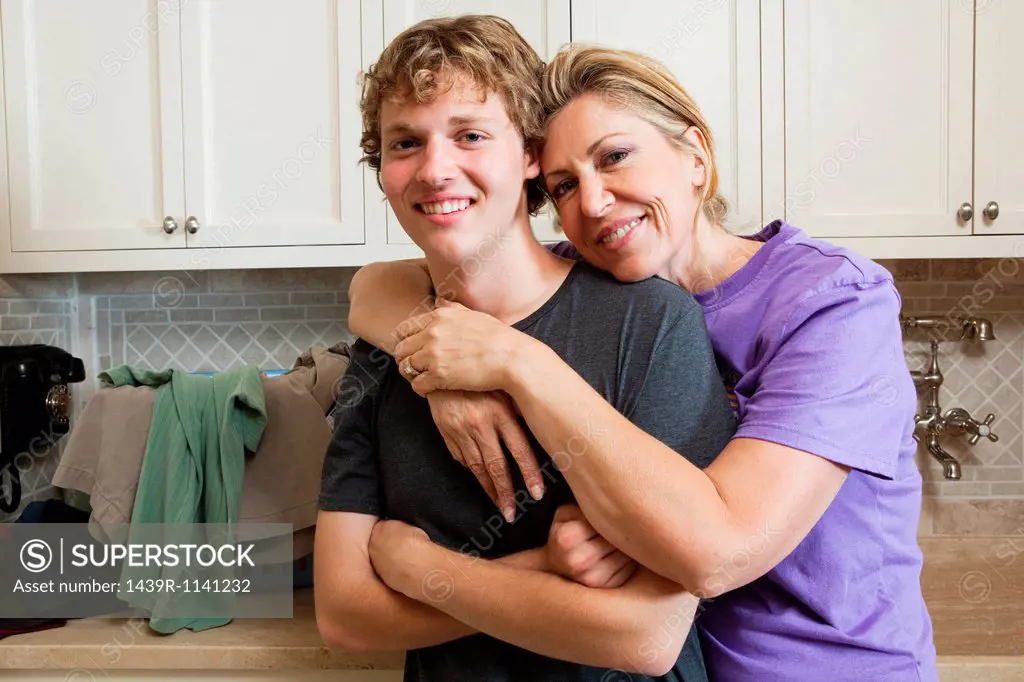 Mature woman and son in laundry room, portrait