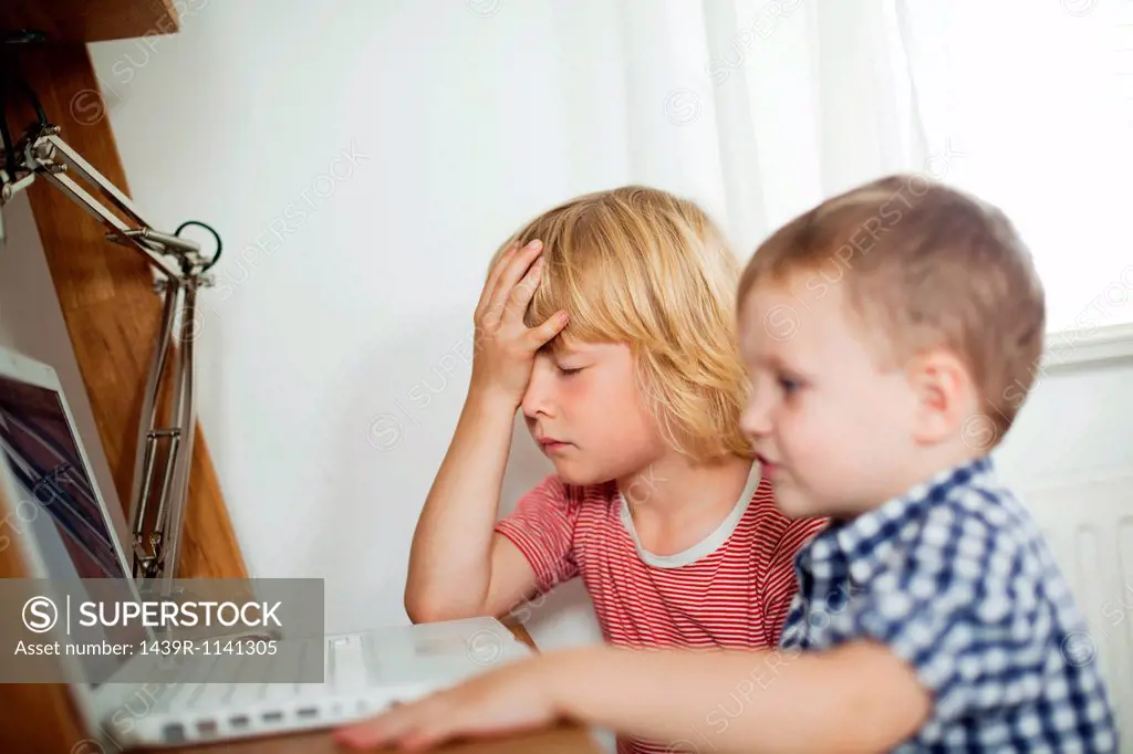 Young boys using laptop at desk