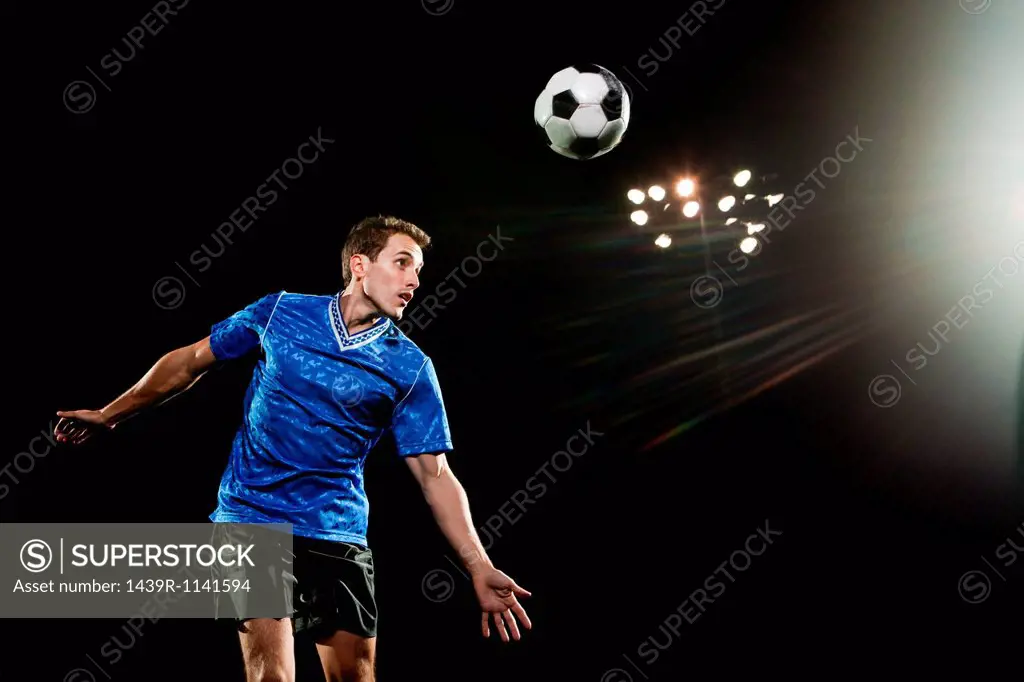 Young man leaping to head soccer ball