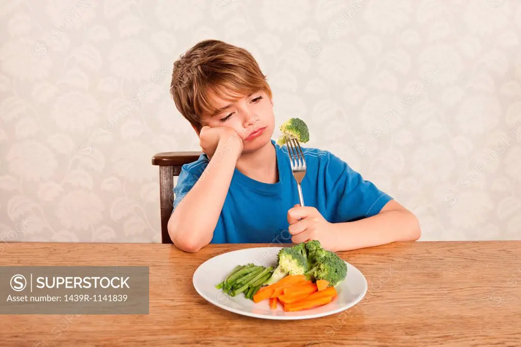 Boy frowning at vegetables