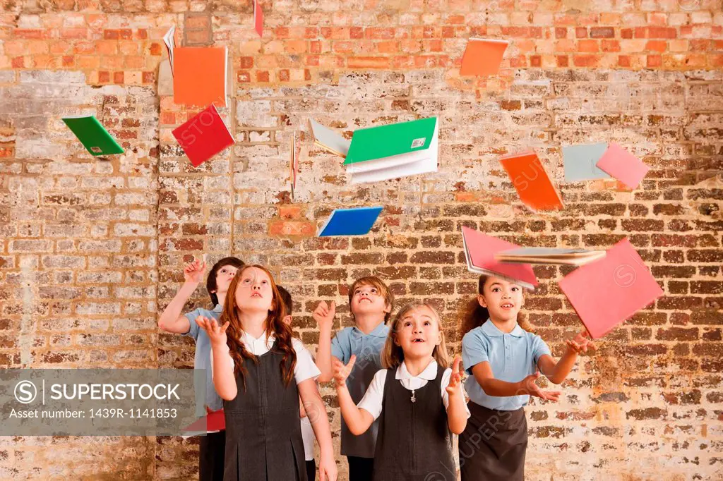 Children throwing books in the air