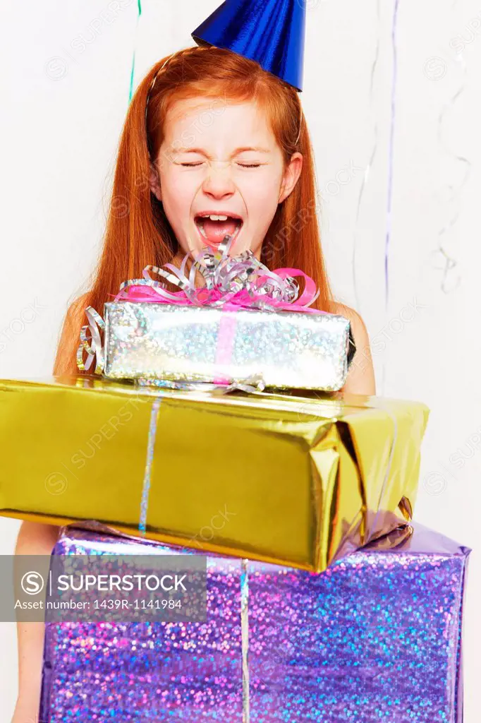 Screaming girl with stack of birthday gifts