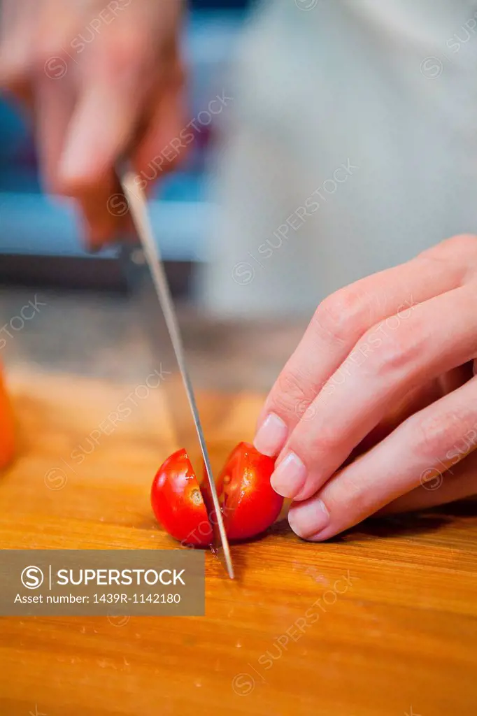 Mid adult woman slicing cherry tomatoes