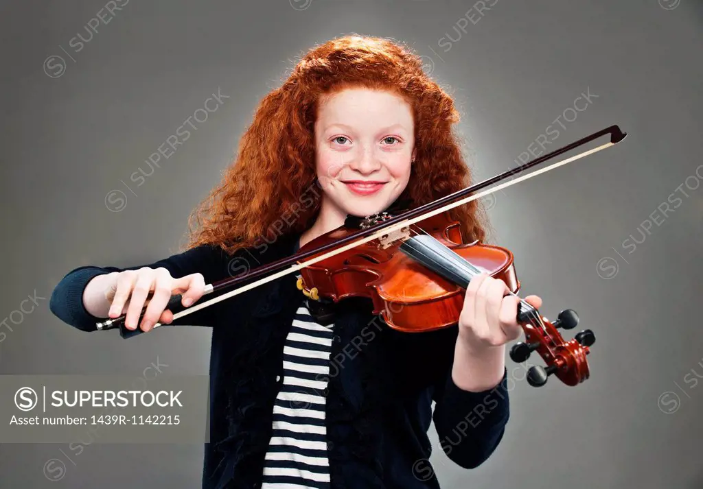 Portrait of mixed race teenage girl playing violin