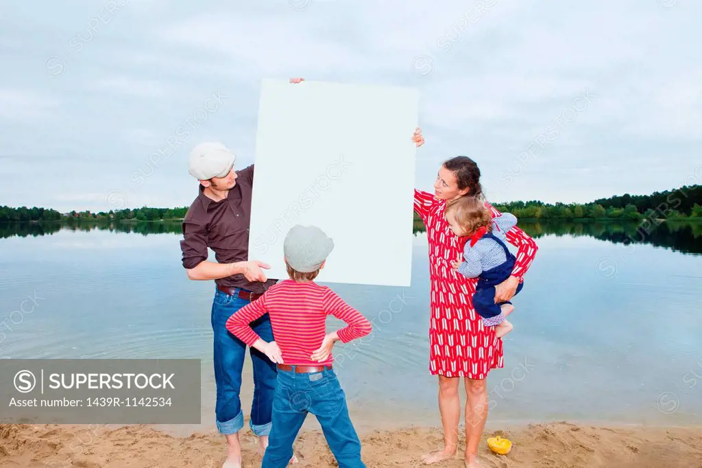 Family by lake, looking at a blank sign