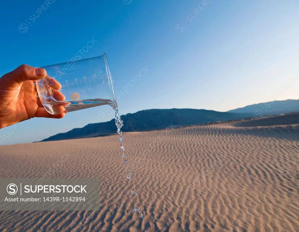 Man pouring water from beaker in Death Valley National Park, California, USA