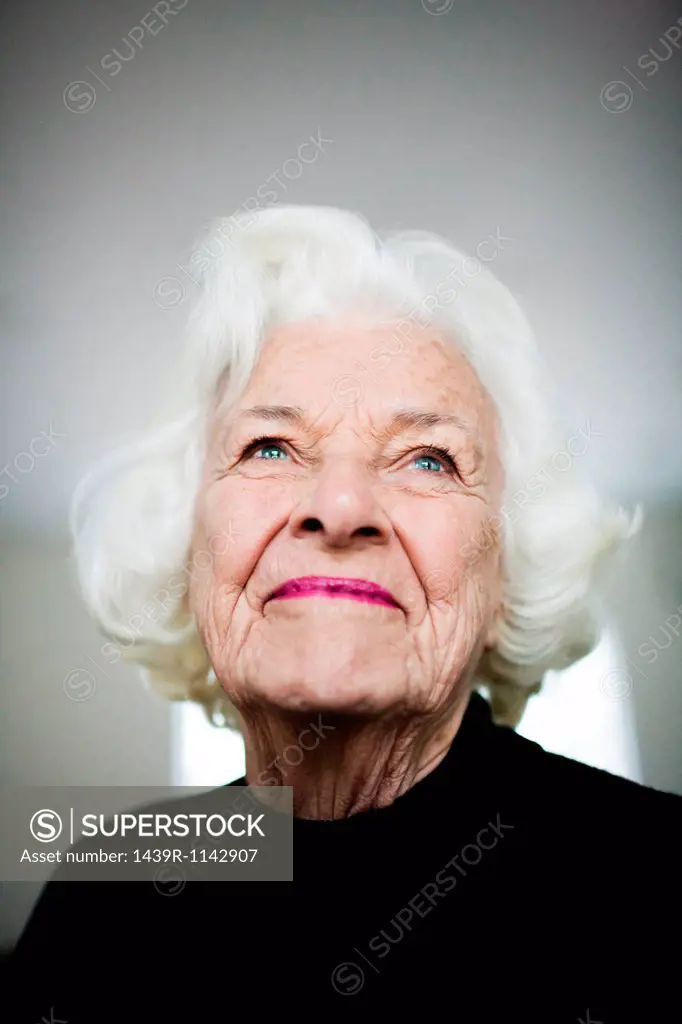 Portrait of senior woman looking up, studio shot