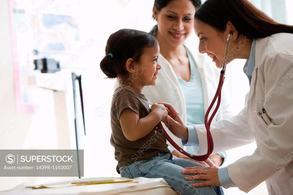 Doctor listening to young girl´s chest with stethoscope