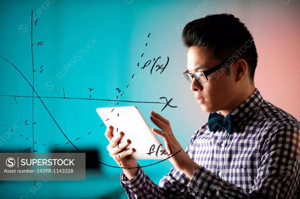 Young man using digital tablet with diagram on window