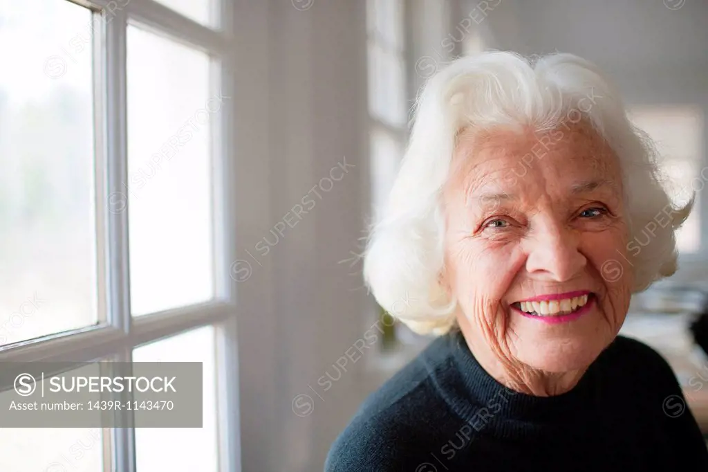 Portrait of senior woman by window