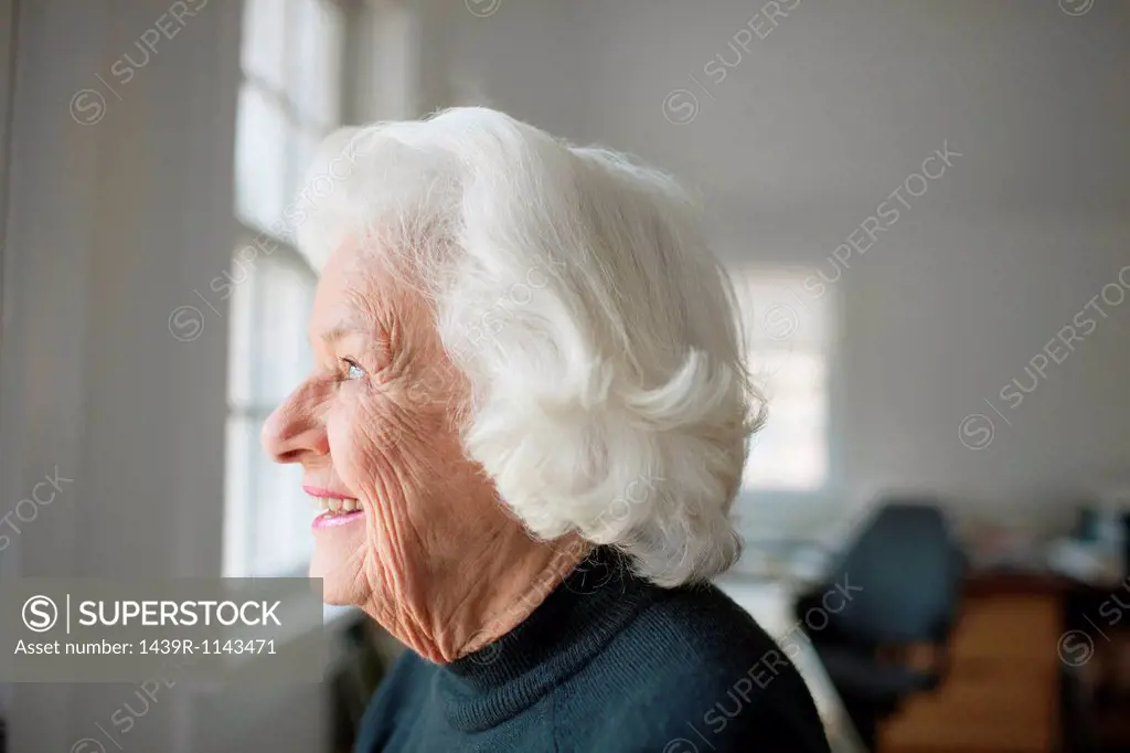 Portrait of senior woman looking out of window