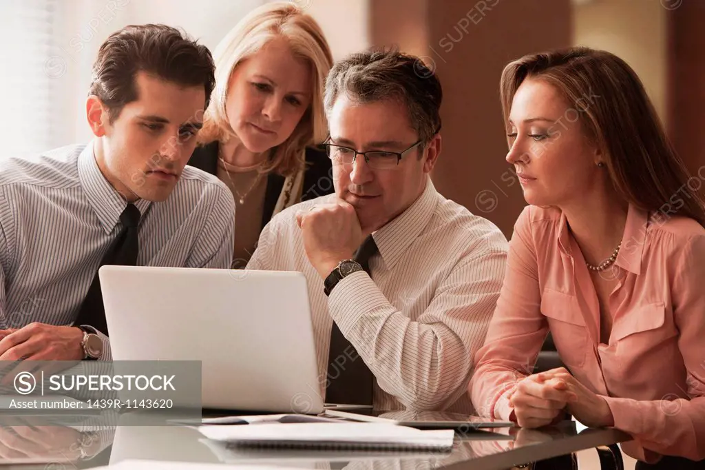 Business colleagues working on laptop on desk