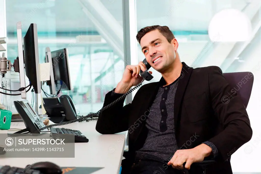 Young man on telephone in IT office