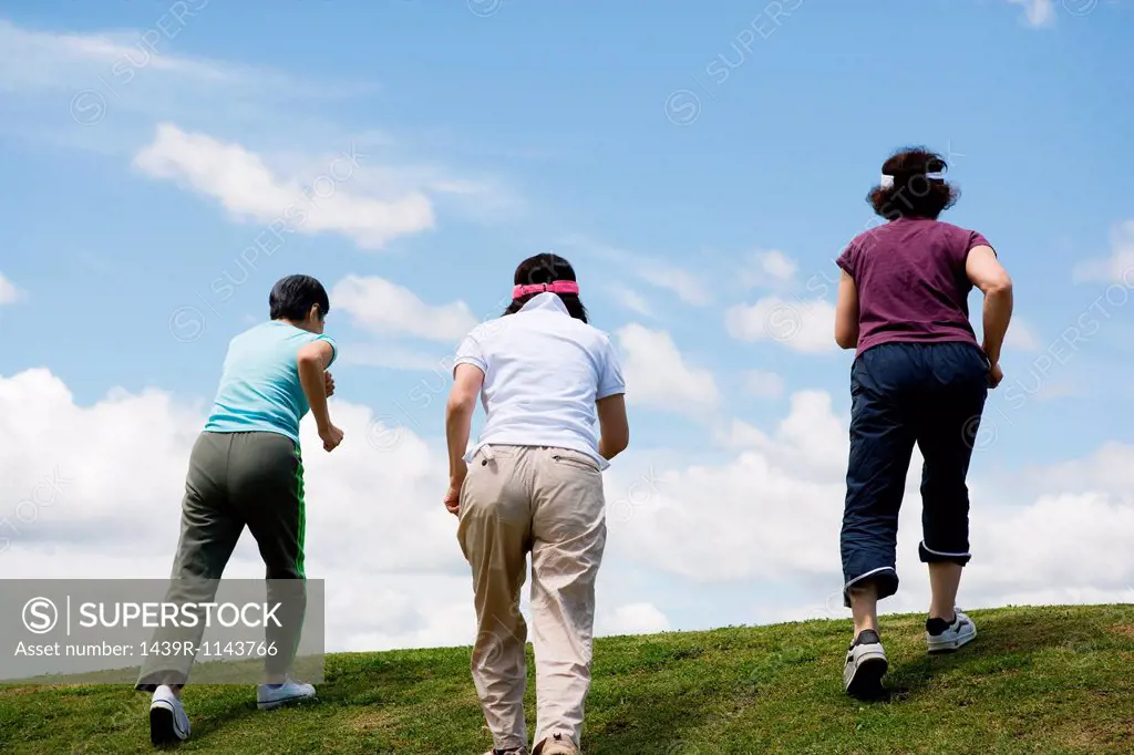 Three senior women walking up a hill