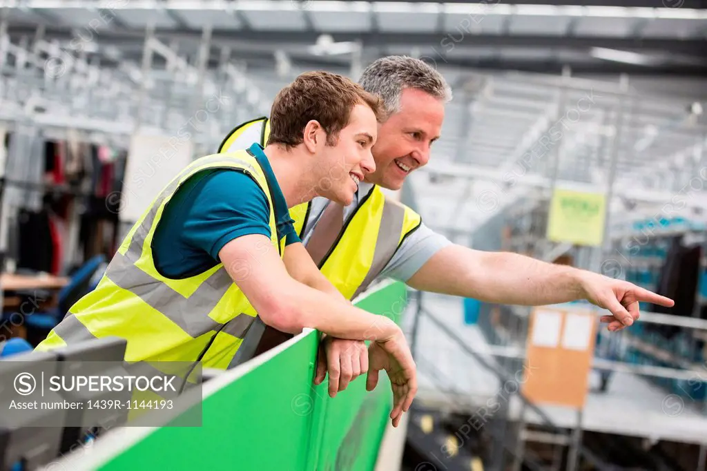 Two men in warehouse, one pointing