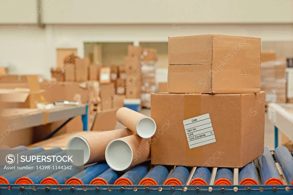 Cardboard boxes and tubes on conveyor belt