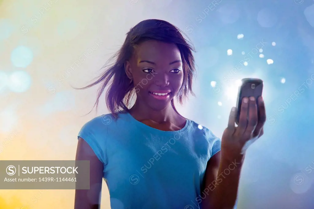 Teenage girl using illuminated cellphone