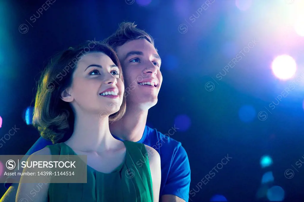 Young couple looking up at lights