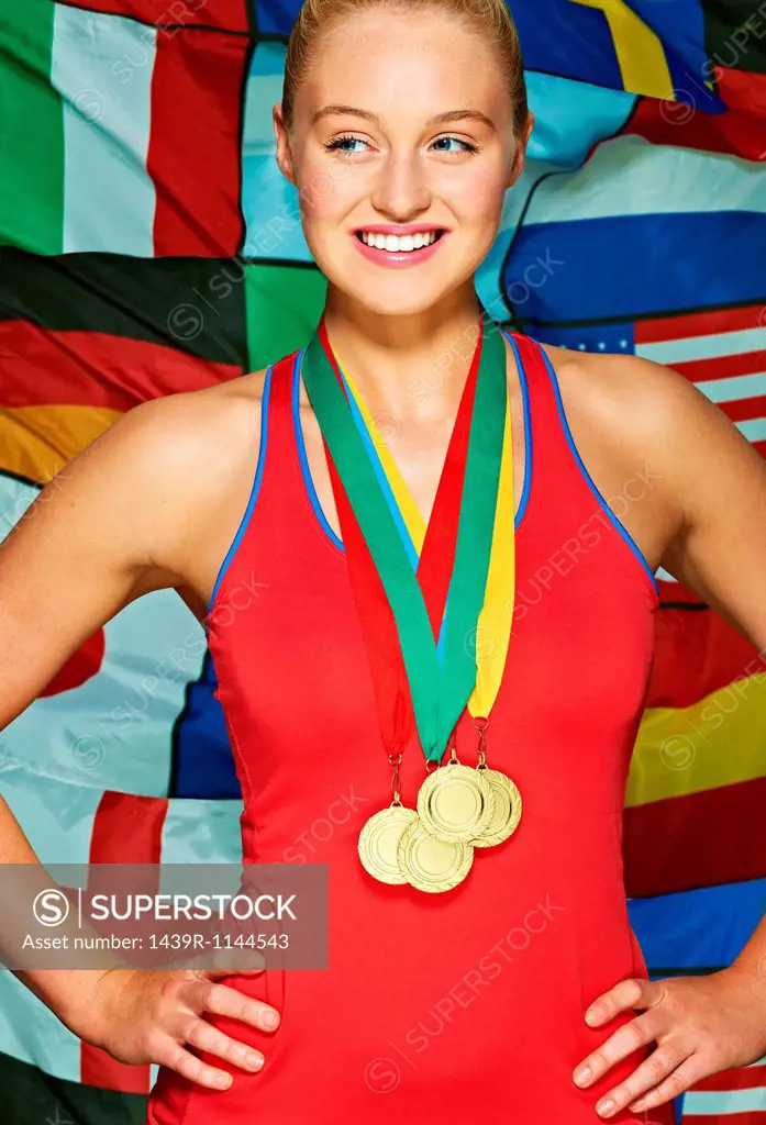 Young woman in front international flags wearing medals
