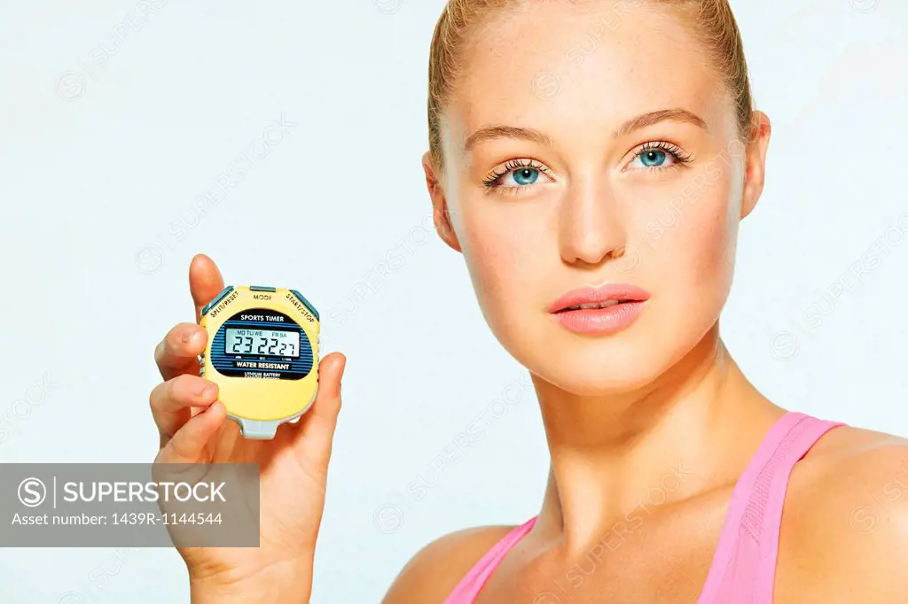 Young woman holding stop watch