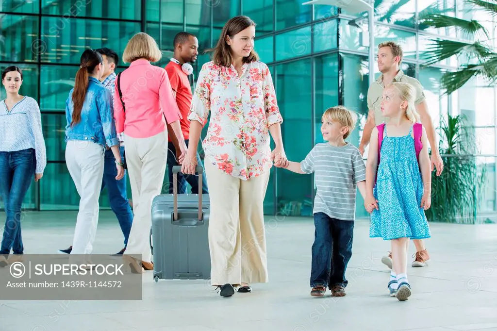 Mother and children walking through airport