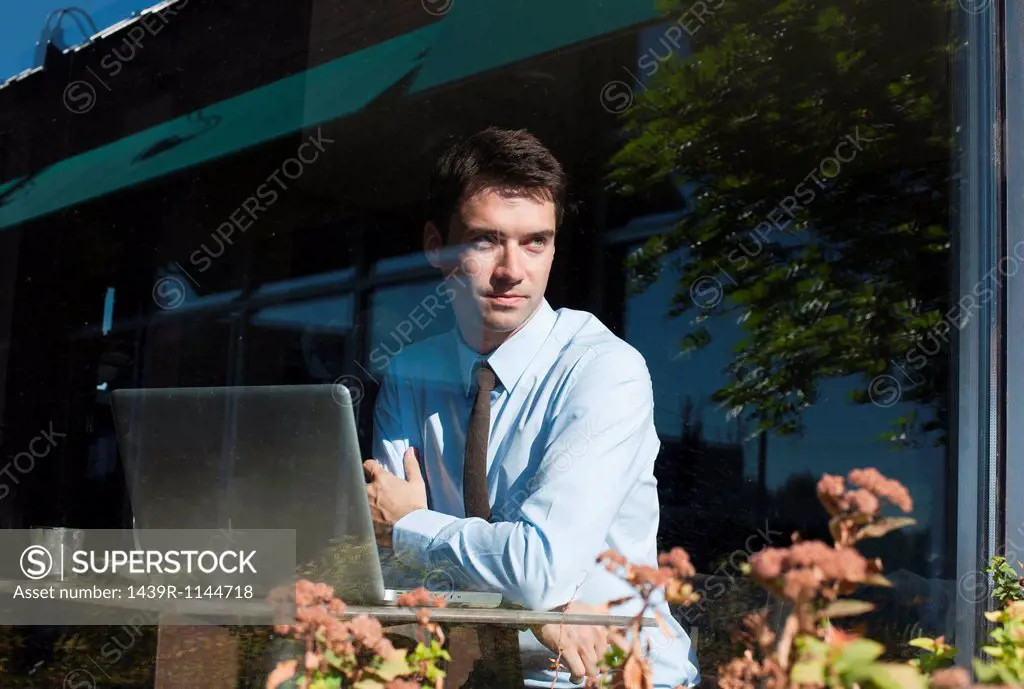 Businessman in cafe, view through window