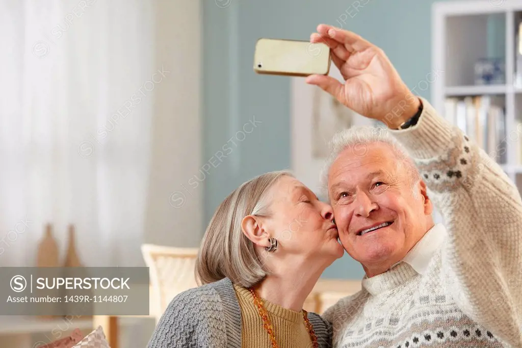 Senior couple photographing themselves with smartphone