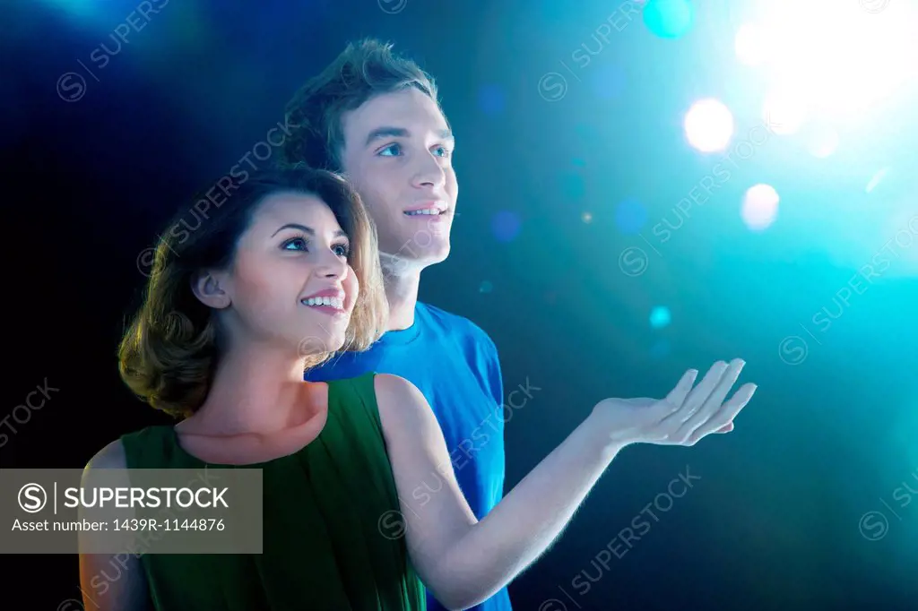 Young couple looking up at light