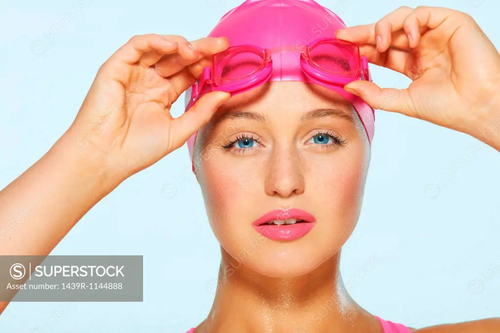 Female swimmer with pink goggles and cap