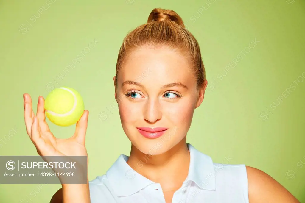 Young woman holding tennis ball