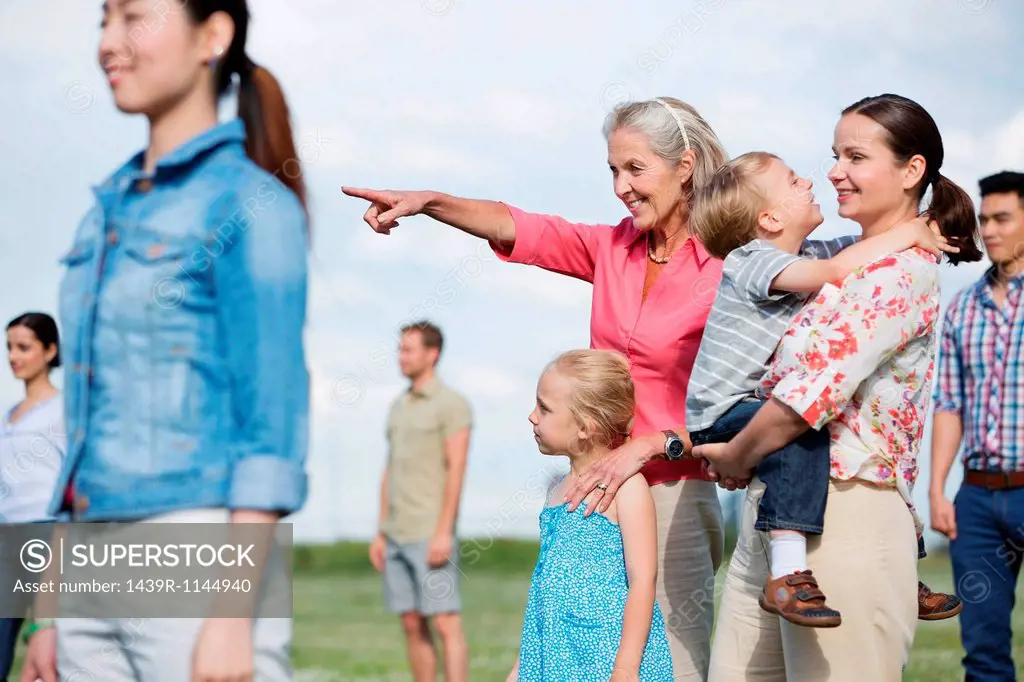 Group of people outdoors, focus on senior woman and family