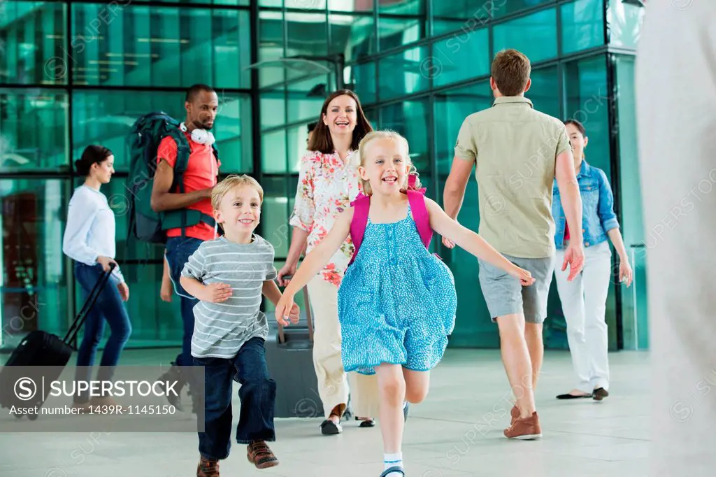 Excited children running on airport concourse