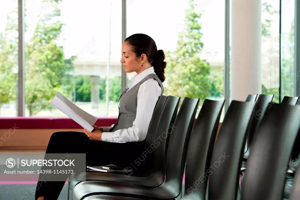 Businesswoman reading document, side view
