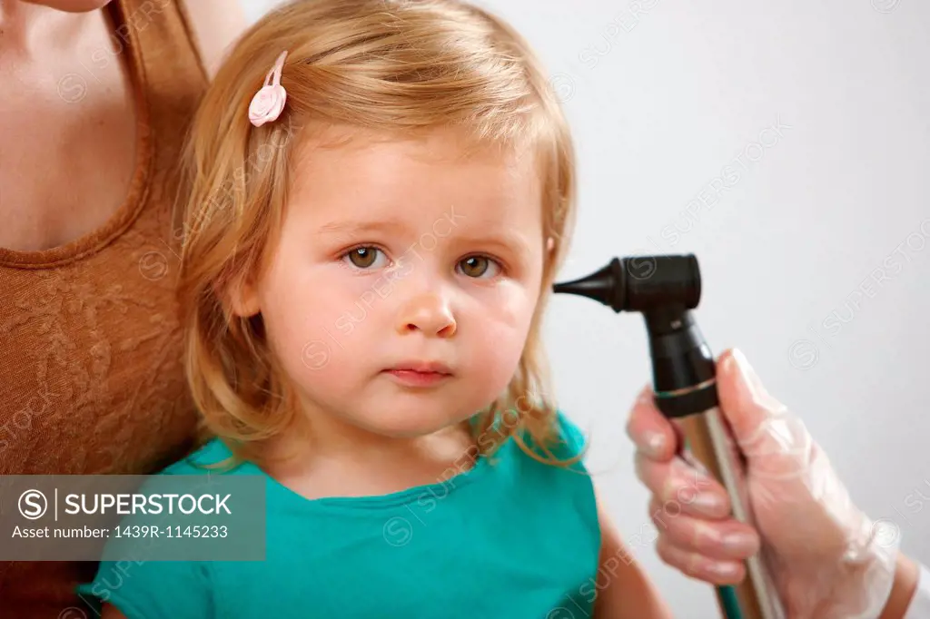 Little girl having her ear checked
